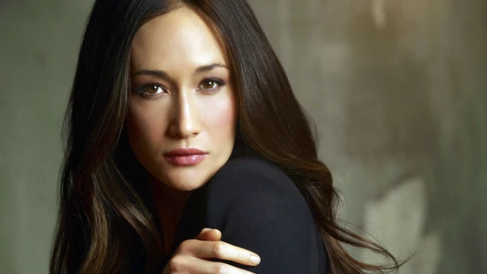 women's black scoop neck top Maggie Q actress looking at viewer