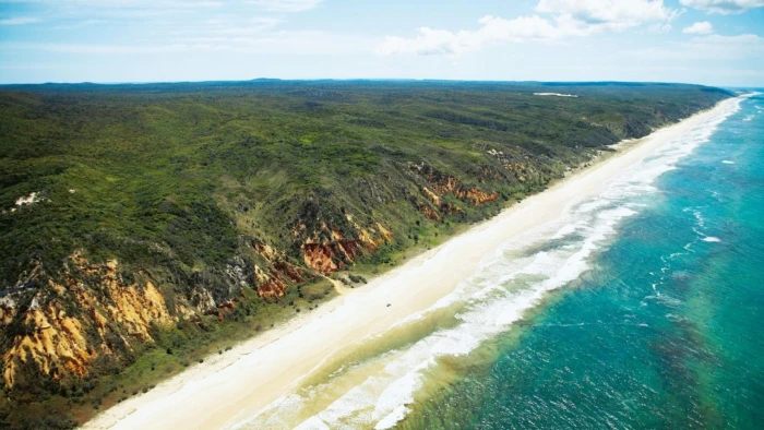 body of water and green hills beach island Australia sand 2k
