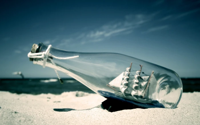 ship in a bottle photography beach water sea bottles sand 2k