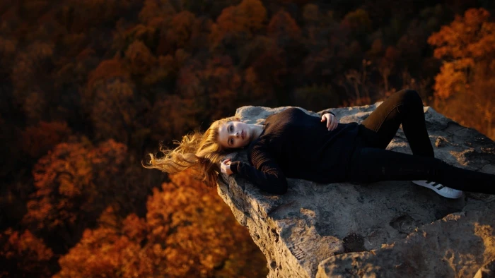 women's black long sleeved shirt woman in laying on rocky mountain 2k