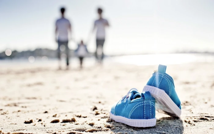shoes beach sand land focus on foreground sea water adult 2k