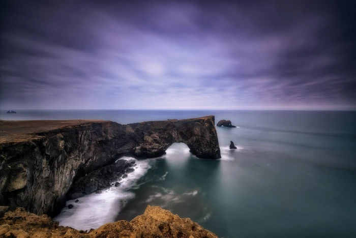black and brown rocks in ocean side during daytime arch Dyrh laey 2k
