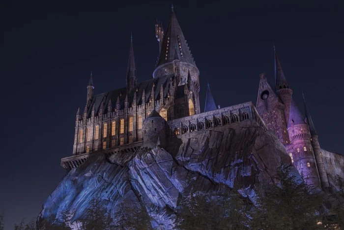 low angle view of lighted gray castle on cliff landscape 2k