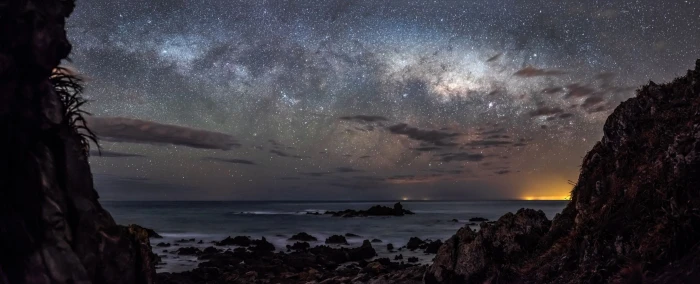 body of water stars night landscape starry sea rock 2k