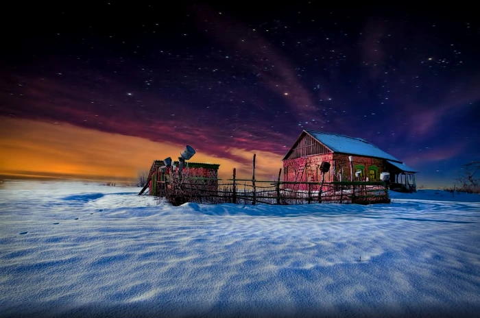 brown wooden house with fence and shed on white ground during starry night 2k