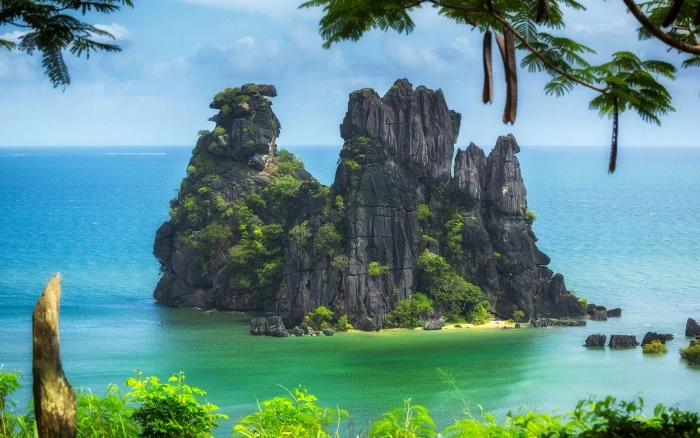 New Caledonia Pacific ocean island trees cliff beach sea rocky in the middle on body of water 2k