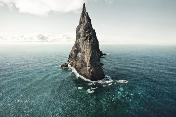 stone spire on water digital wallpaper gray rock formation body of 2k