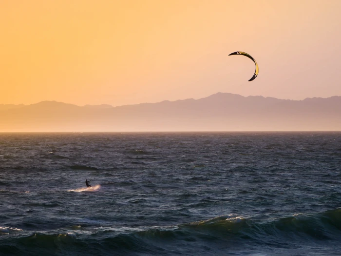 kitesurfing during golden hour person kite surfing at sunset 2k