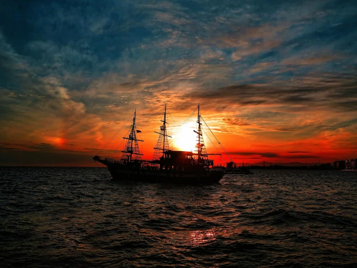 silhouette of sailing boat fishing boats on body water during sunset 2k