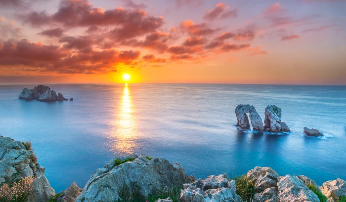 body of water near rocks during sunset Far away cantabria spain 2k