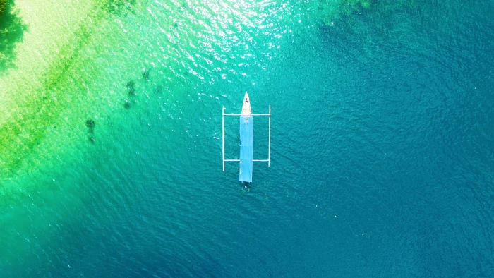 White Boat on Calm Body of Water aerial shot beach color drone 2k 4k