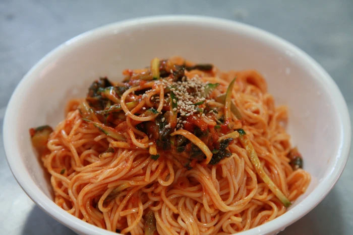 spaghetti with vegetables in bowl korean food bibim guksu noodles 2k 4k