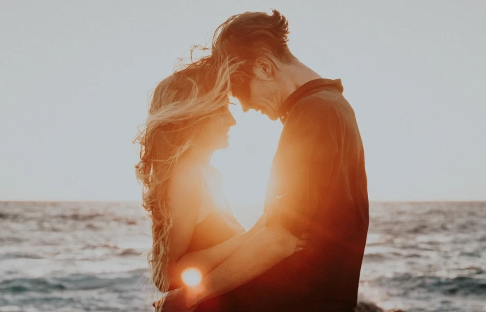 man and woman facing face to with sun glaring between them 2k
