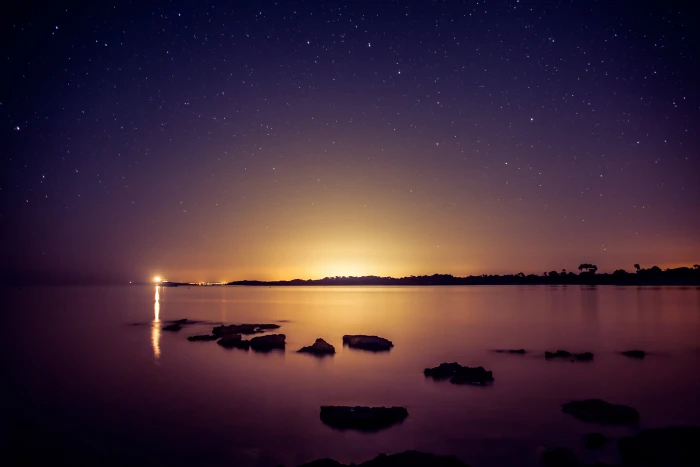 silhouette of rocks on water during golden hour Amanecer artificial 2k 4k 5k