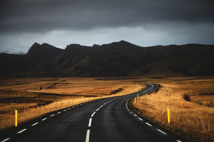 black concrete road near brown grass under cloudy sky iceland 2k 4k
