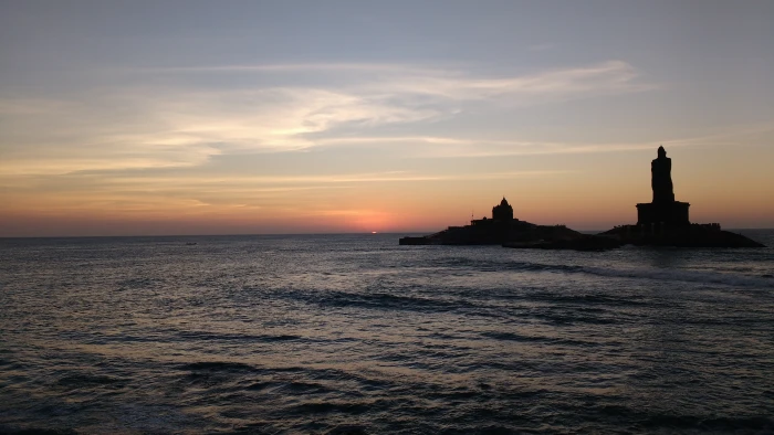 lighthouse beside body of water under calm sky kanyakumari sunrise 2k 4k