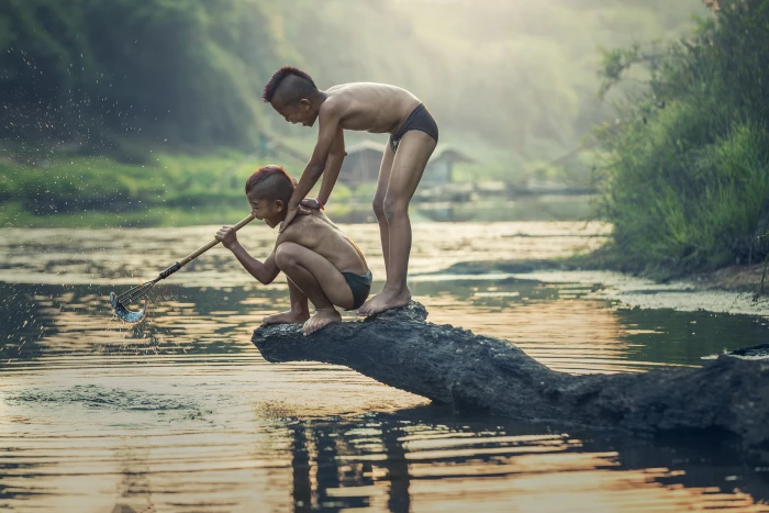 photo of two boys standing on rock top body water talented people 2k 4k 5k