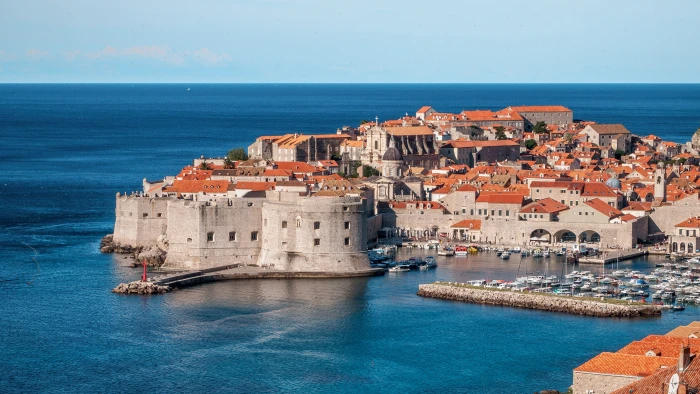 gray concrete building surrounded by water under blue sky dubrovnik 2k 4k