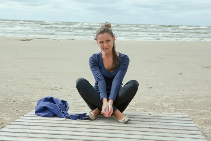 women model Sophia E legs crossed on beach looking at viewer 2k 4k 5k