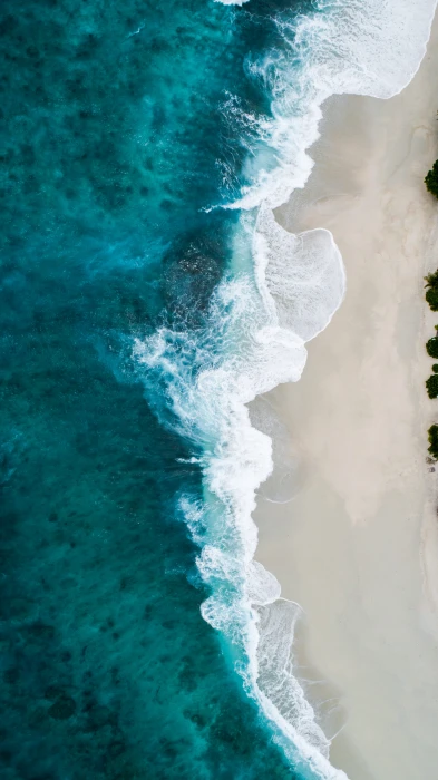 aerial photography of large body water and shoreline photo seashore waves during daytime 2k