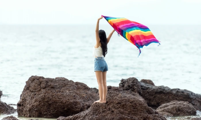 Girl standing on a rock with blanket the seashore in Maldives 2k 4k 5k