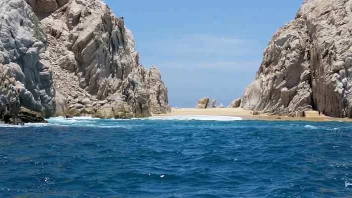 rock formation on body of water during daytime beach island 2k 4k 5k