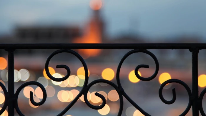 black metal wrought iron fence bokeh no people close up focus on foreground 2k