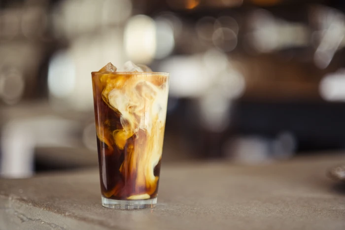 glass cup filled with ice latte on tabletop tilt shift photography of iced coffee 2k 4k 5k
