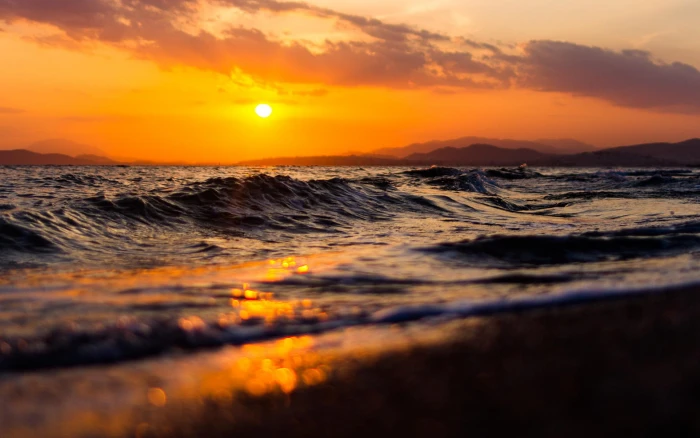 photo of seashore during golden hour waves sunset depth field 2k