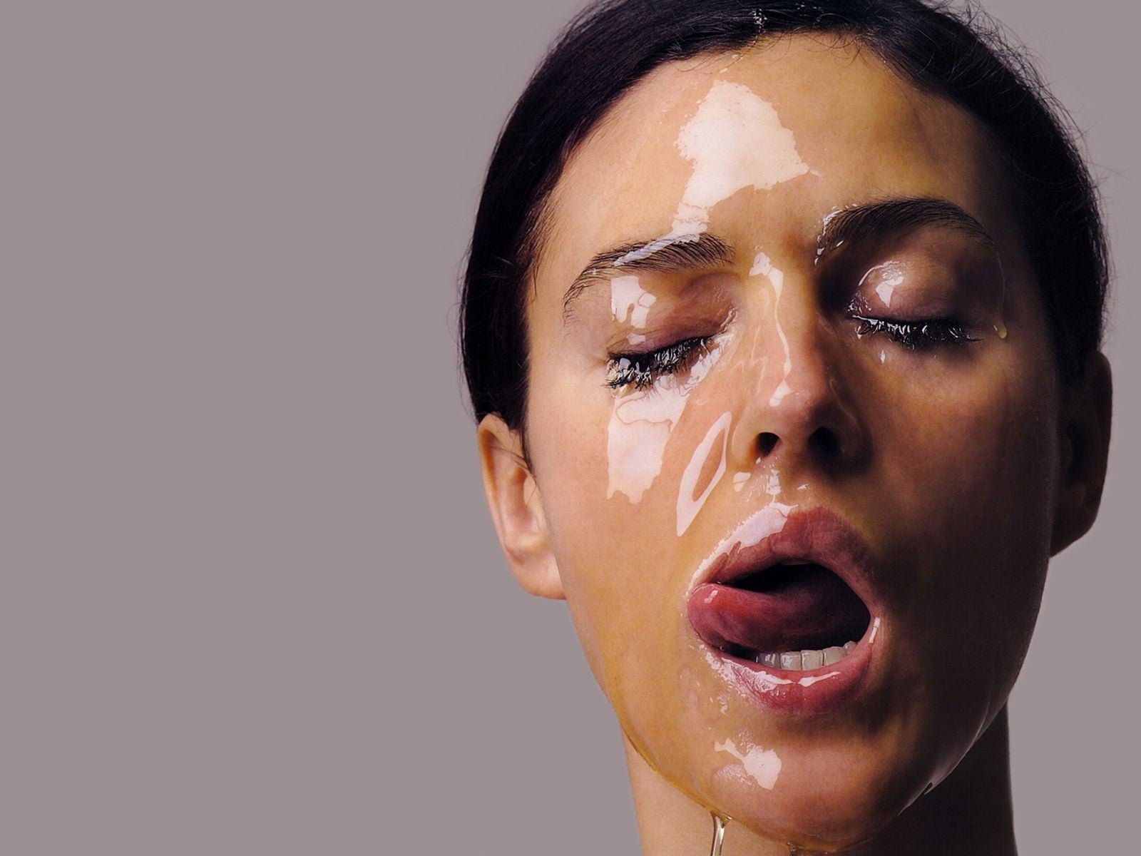 woman's face Monica Bellucci actress licking lips honey closed eyes