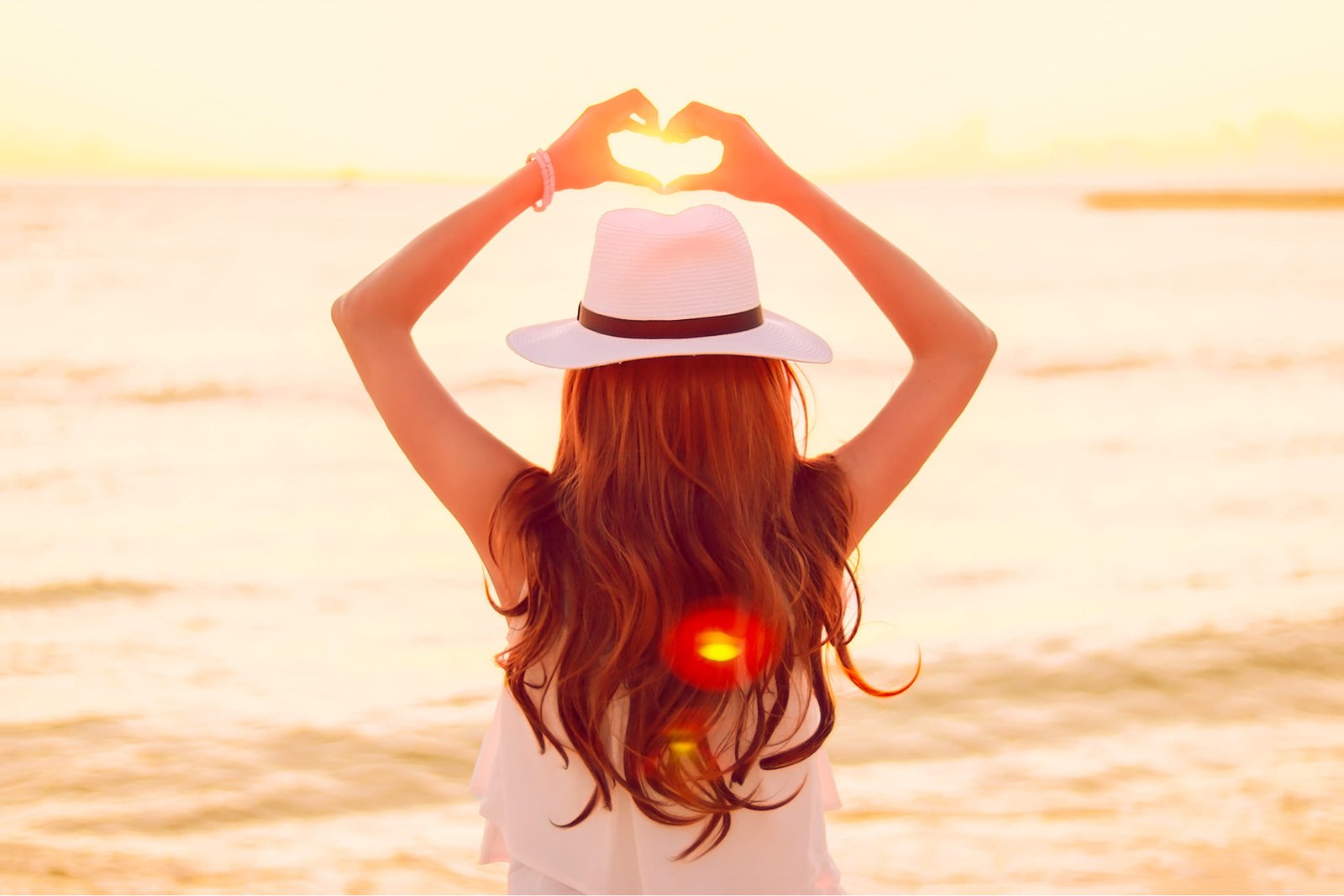 woman in white fedora hat sleeveless top standing near body of water 2k