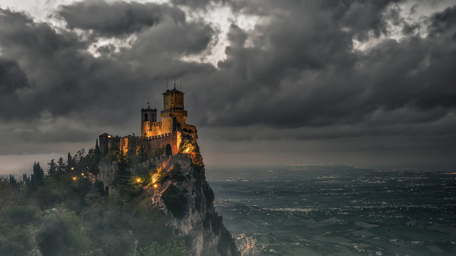 brown concrete castle on edge of cliff with sea at the bottom 2k