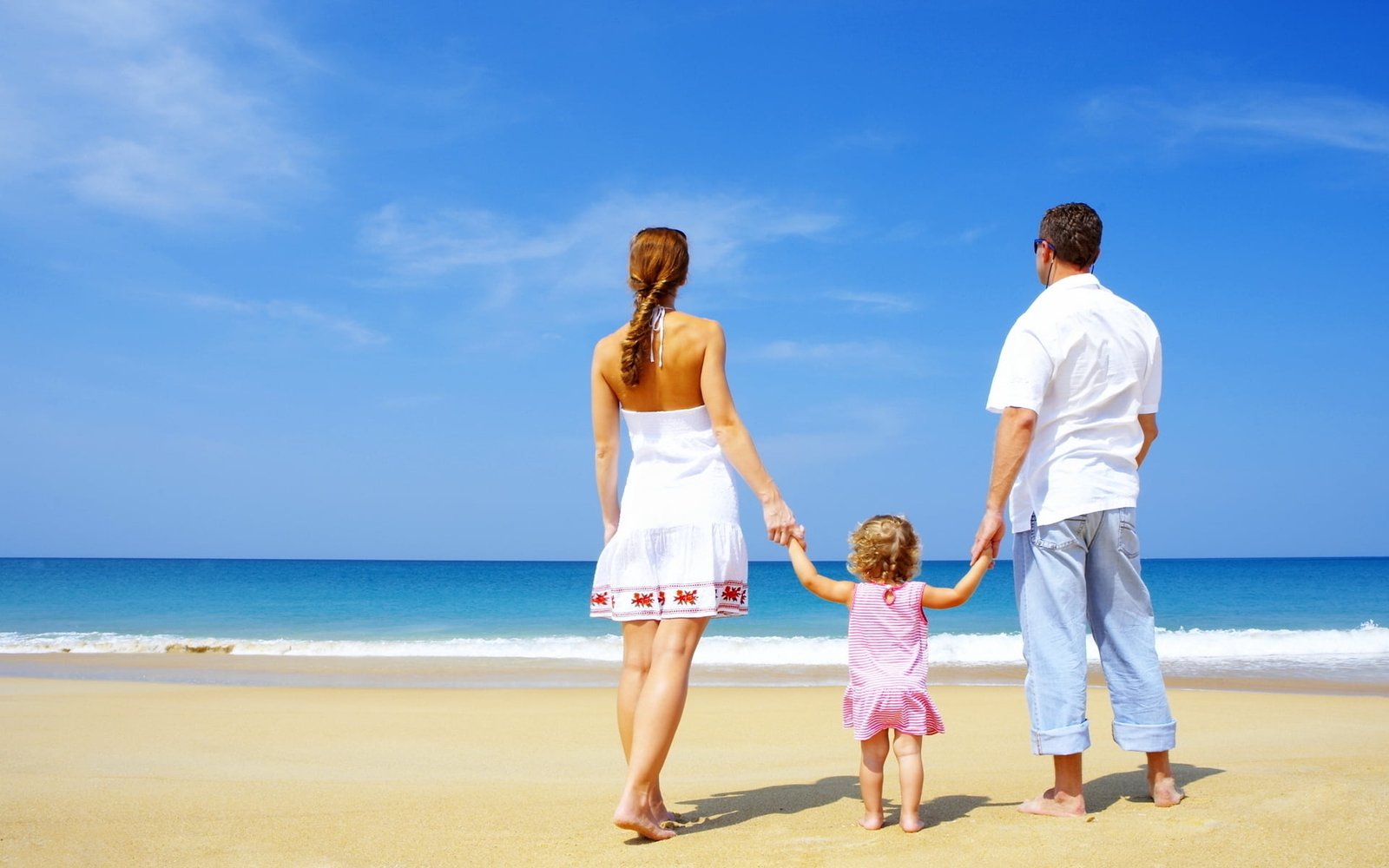 girl walking between woman and man while holding hands towards shore during daytime 2k