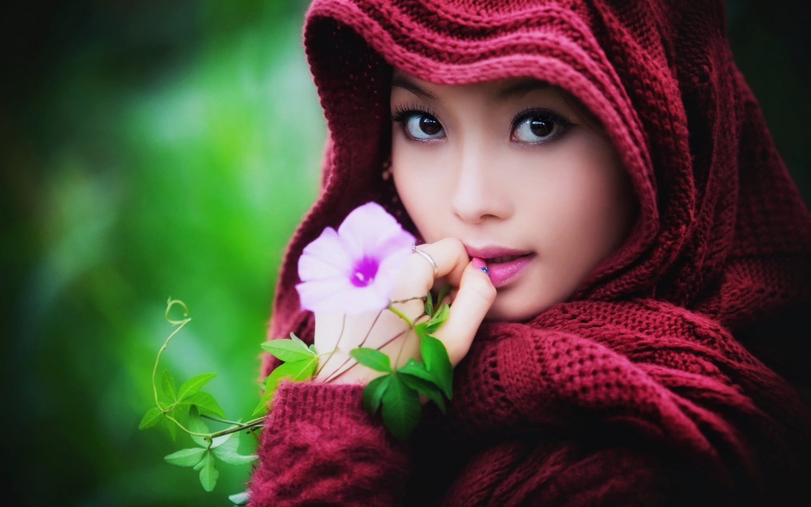 women's red top woman wearing knitted headscarf near pink petaled flower 2k