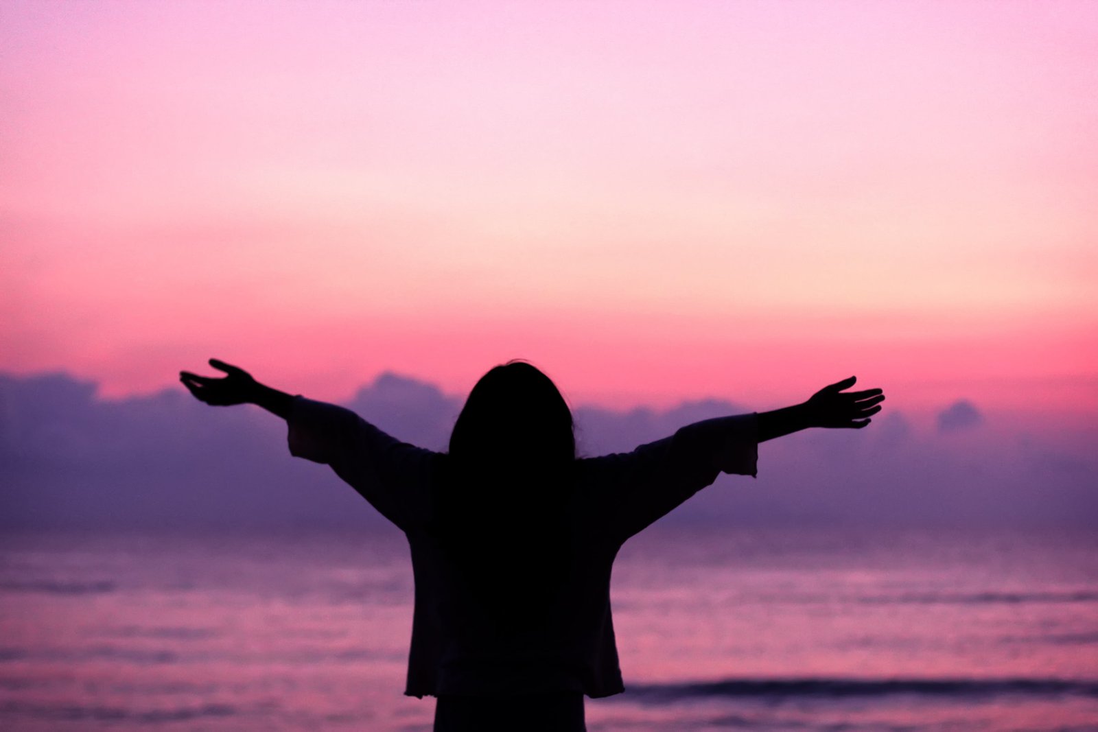 woman opening his arms wide in the seashore feast gratitude 2k
