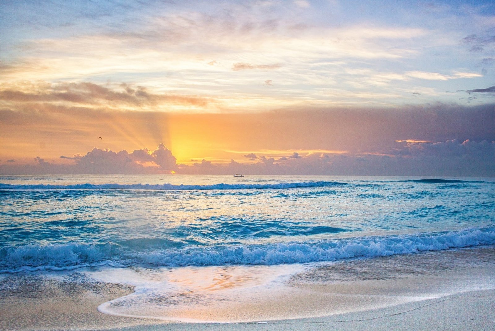 body of water and white sand photo taken during daytime sunrise 2k