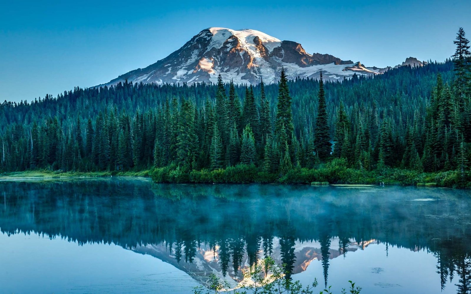 snow capped mountain surrounded with trees near body of water 2k