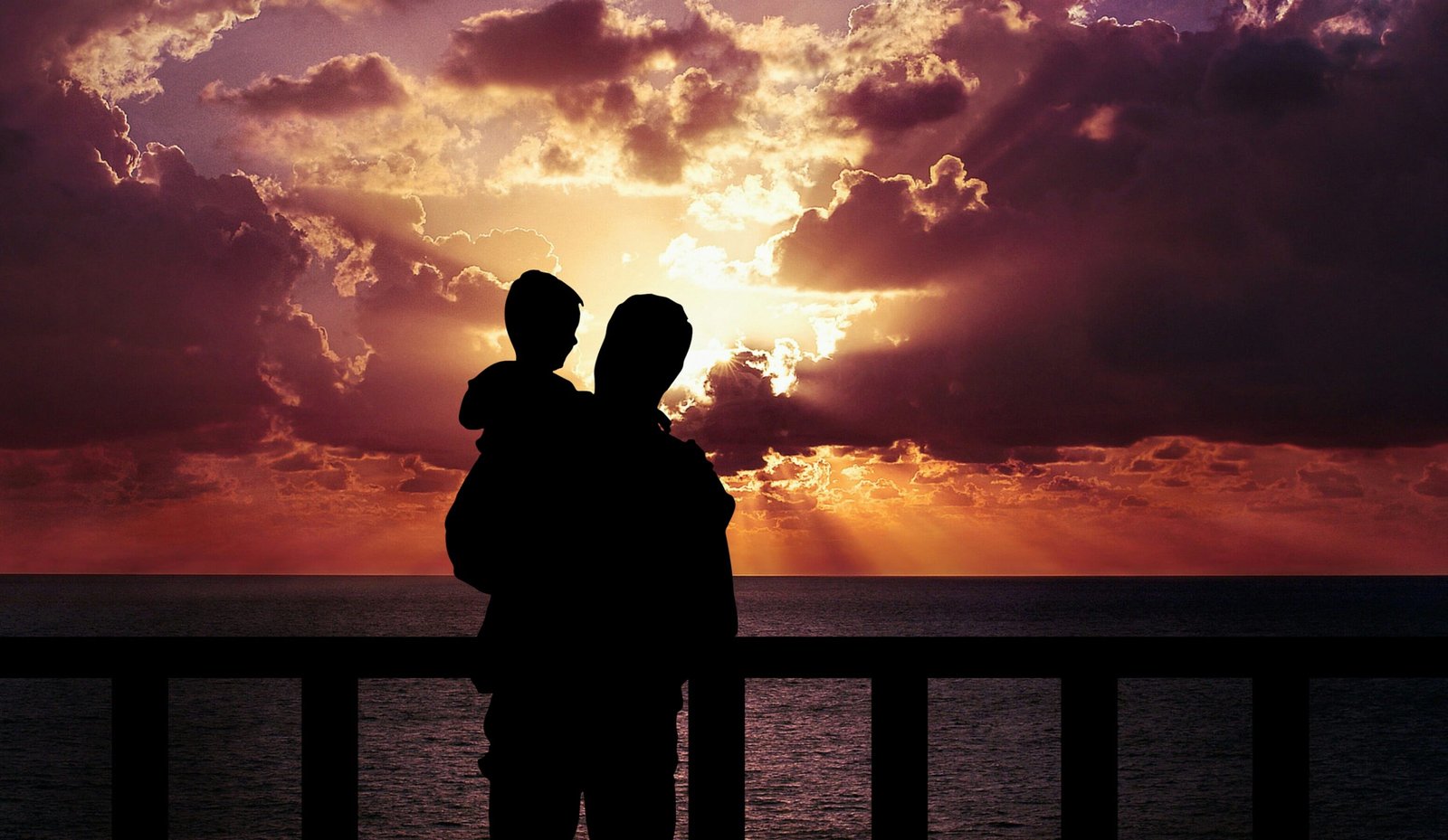 silhouette of man holding toddler during golden time father and son 2k