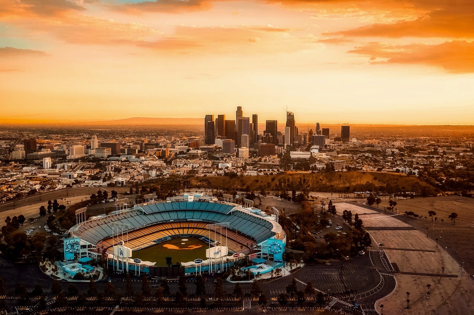 grey and black baseball stadium overlooking skyscraper under sunset sky 2k