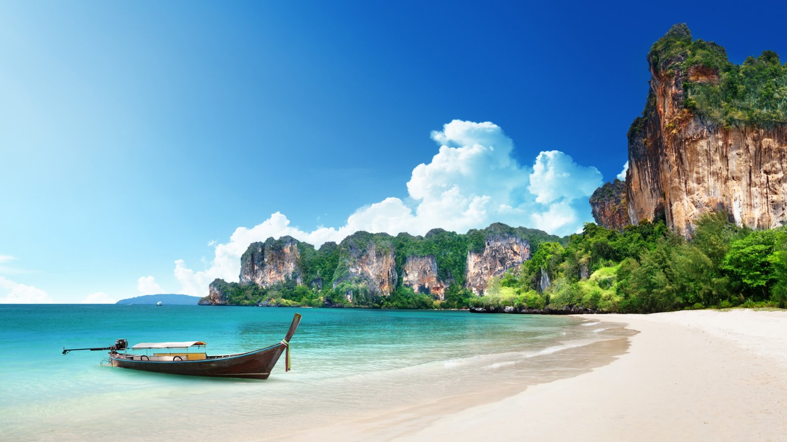 black boat on white sand beach near brown cliffs Thailand 2k 4k