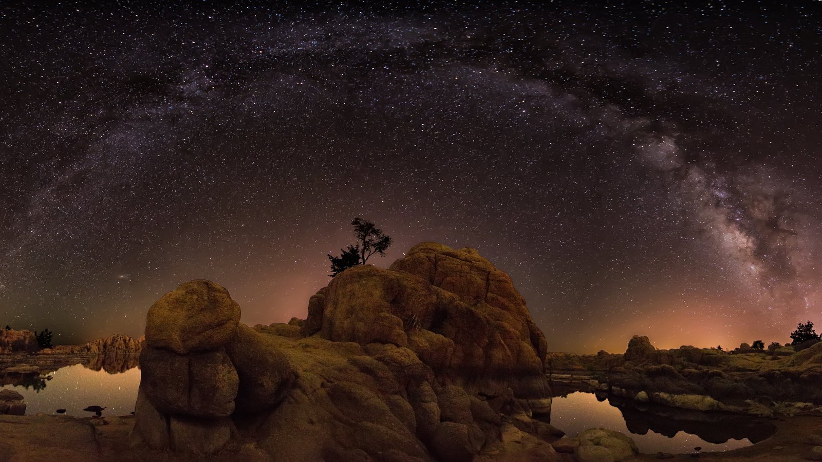 rock formation under starry night brown island near body of water 2k 4k