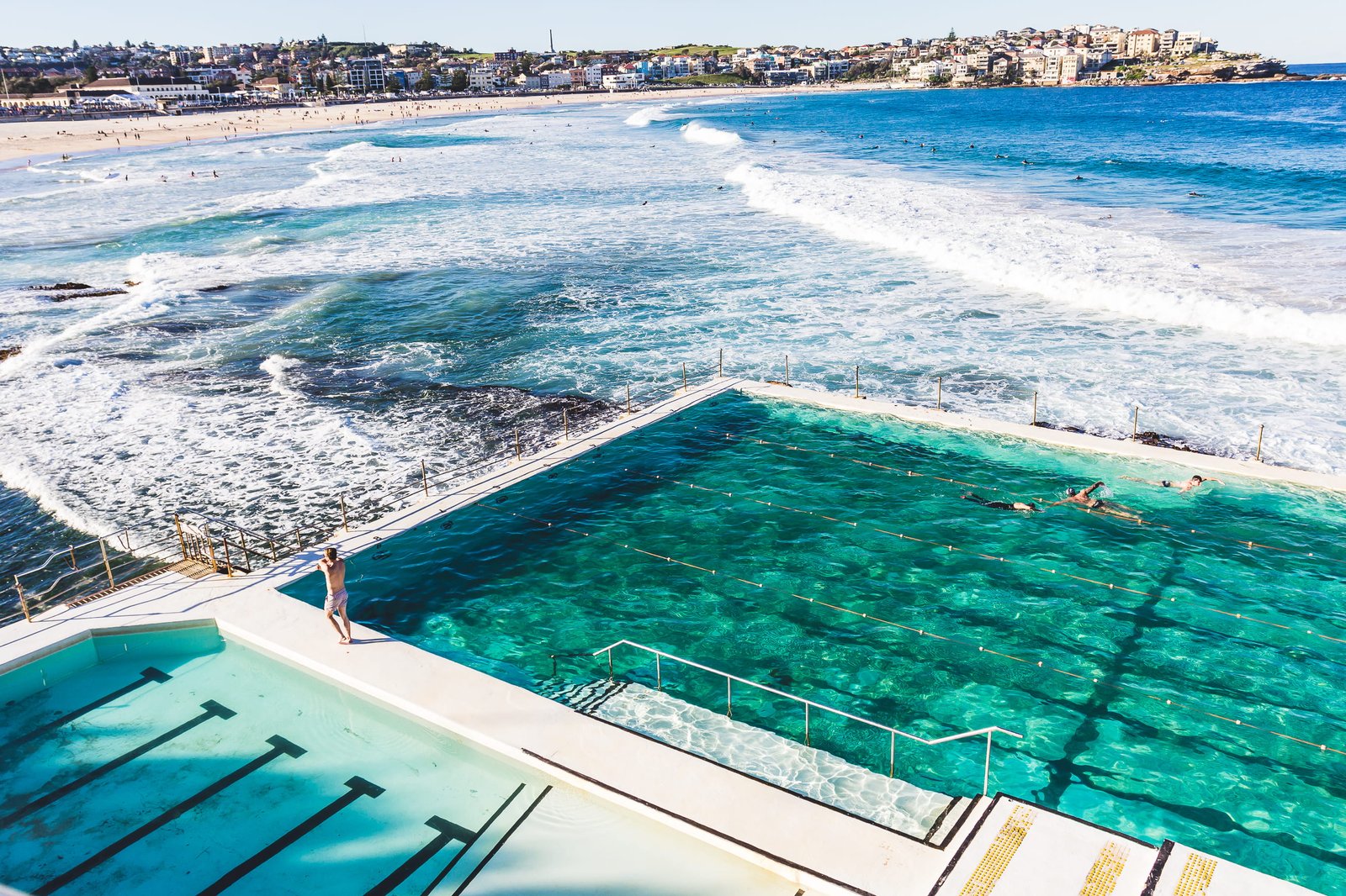 bird s eye view photography of person standing beside swimming pool near to beach 2k