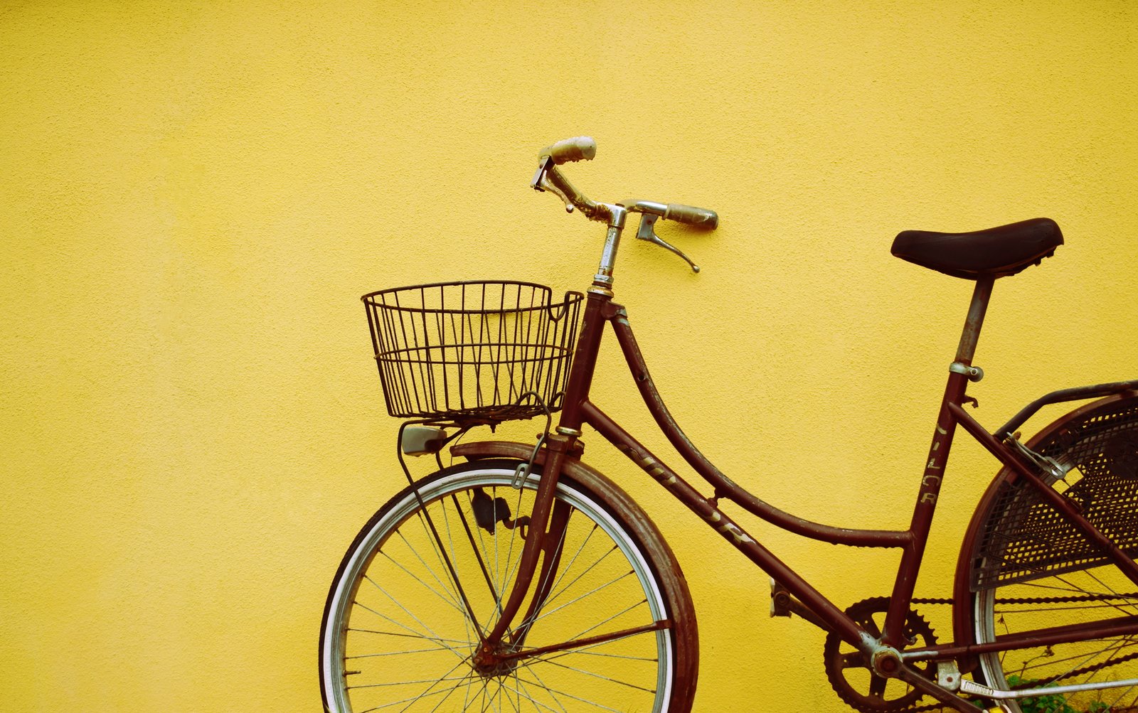 female beach cruiser bike leaning on yellow painted wall brown park beside 2k 4k 5k