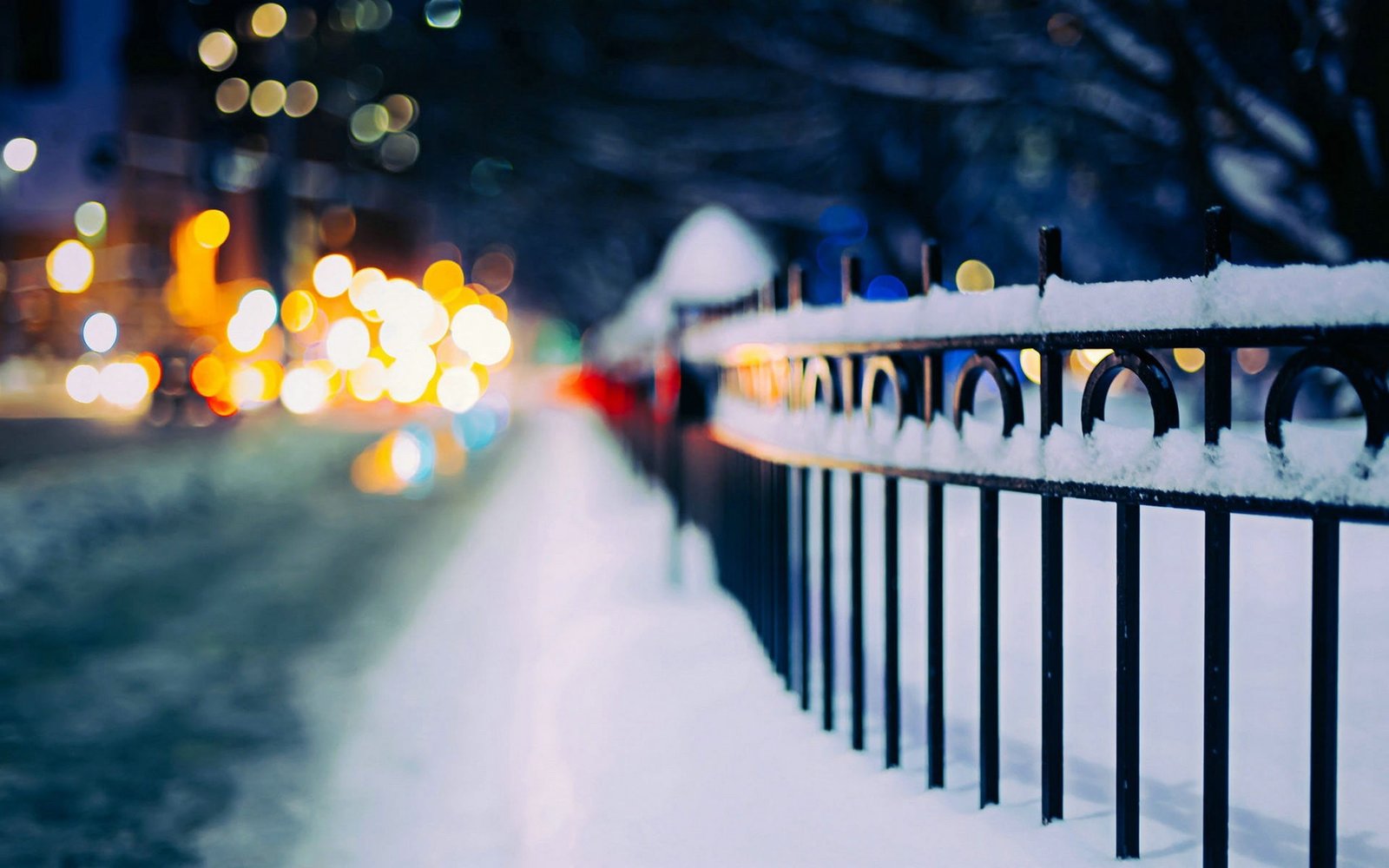 black metal fence covered with snow urban street 2k