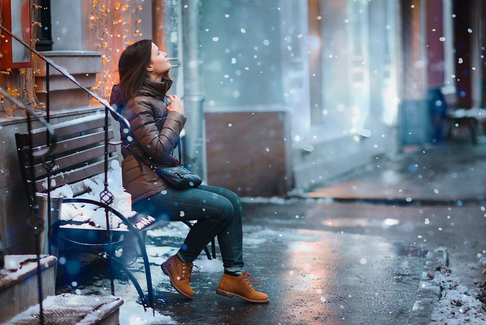 women s brown zip up bubble jacket woman wearing winter sitting on bench 2k