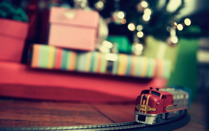 selective focus photography of red and gray train toy on brown wooden surface