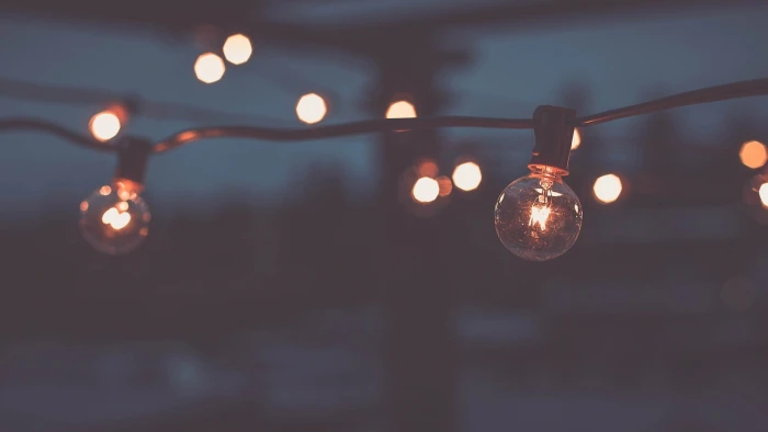 clear bulb string lights shallow focus photography of during night time