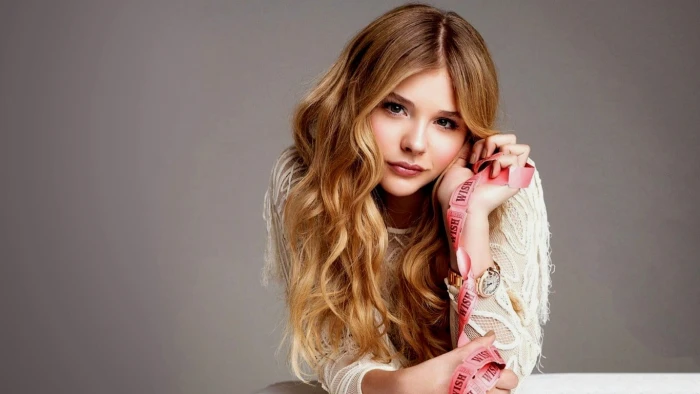 woman holding a pink ribbon on both her hands Chlo Grace Moretz