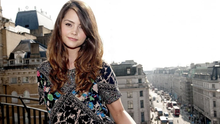 women's black pink and blue floral top woman wearing dress with buildings cars on street in background