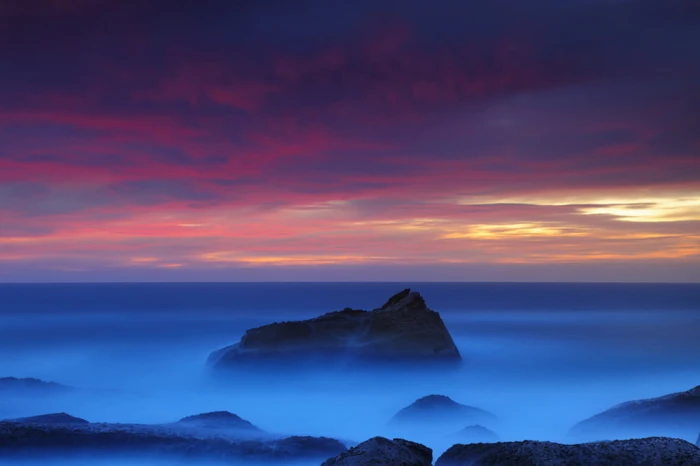 mountain range under red and yellow sky North Avalon Colour